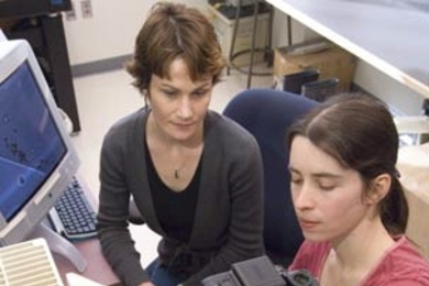 Sheri Simmons uses a pipette to place water samples onto a microscope slide to look at the swimming behavior of magnetotactic bacteria. Her advisor and co-author, Katrina Edwards, is at left.