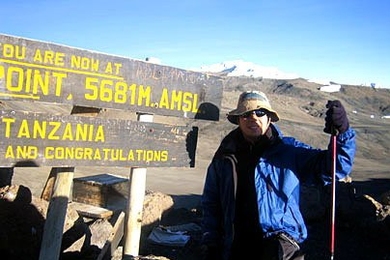 Graduate student Christopher Lowell, who went to Africa as part of Sloan's Global Entrepreneurship Laboratory, takes in the sunrise at Gilman's Peak in Tanzania. He eventually made it to the summit of Mount Kilimanjaro with G-Lab partner Zhiying Jiang.