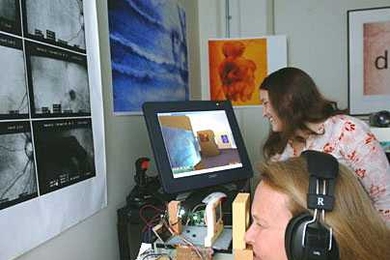 Elizabeth Goldring, foreground, looks into 'seeing machine' to take a virtual tour of a gallery using a joystick. Her assistant, Jackie McConnell, is at right.