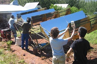 Interns at Appropriate Technology Services in Lesotho work with graduate student Amy Mueller, second from right, and sophomore Perry Hung, right, on the MIT solar micro-generator in January.