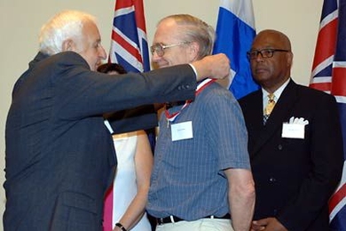 Marshall Sloane, Chairman of Century Bank, left, bestows the Distinguished Eagle Scout Award on Professor Kim Vandiver, Edgerton Center founder and former Eagle Scout, as Cambridge Mayor Kenneth Reeves, right, looks on.