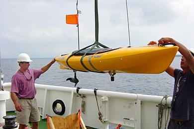 MIT research engineer Joseph Curcio, left, helps launch a SCOUT for experiments conducted off the island of Pianosa, Italy, in July 2005.