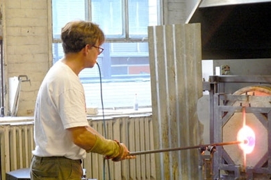 Peter Houk, technical instructor and glass artist in the MIT Glass Lab, shapes a piece that will model color for students of the lab.
