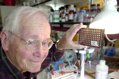 In a photo from 2002, Professor Vernon Ingram holds up cell cultures that he and senior technical associate Barbara Blanchard worked with during their research on the beta-amyloid plaques that attack the brains of Alzheimer's patients.