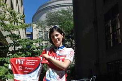 Graduate student Sonya Cates displays one of the MIT cycling team's jerseys that will be auctioned off on eBay to help support the team. The shirt was signed by four MIT Nobel laureates and the winner of the 2003 Turing Award.