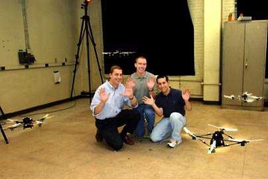 Jonathan How, a professor in aeronautics and astronautics, joins graduate students Brett Bethke, center, and Mario Valenti, right, in demonstrating their "hands-off" technique of simultaneously controlling four fully-autonomous flying vehicles using a PC.