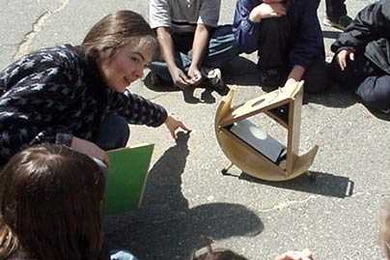 Irene Porro demonstrates how to use a 'sunspotter' to safely show the sun and sun spots on it to a group of Somerville schoolchildren in 2001. Porro, education and public outreach scientist at the MIT Kavli Institute, has recently helped secure a grant to develop a youth astronomy apprenticeship program at MIT.