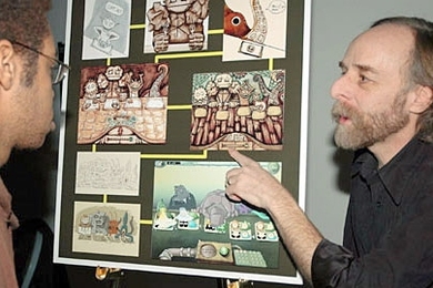 Scot Osterweil, creative director of the CMS Education Arcade, shows freshman Paul Medlock-Walton a game designed to teach math and literacy to middle school students.