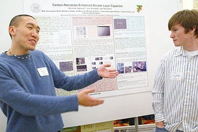 Senior Andrew Lee welcomes sophomore Dan Rogers to a presentation on carbon nanotube capacitors.