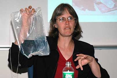 Amy Smith displays a bag, designed in part by one of her students, that is used in a simple water disinfection process. The bag is patented, but can be distributed free in Third World countries.