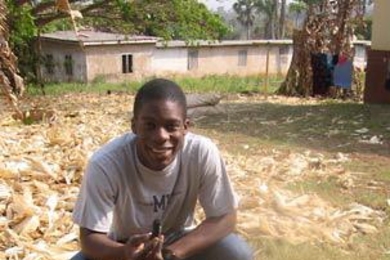 MIT senior Jules Walter in Ghana. He is holding a sample of  charcoal made from corncobs.
