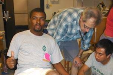 From left, Clarel Jerome of Haiti, a participant in MIT's International Development Design Summit; Gwyndaf Jones, a bicycle expert from the U.S., and Carlos MarroquÃ­n, a participant and Native American from Guatemala, are using a pedal-powered device to mill corn for the participants to cook. <a onclick="MM_openBrWindow('summit-4-enlarged.html','','width=509, height=583')">
<span onmouseover="...