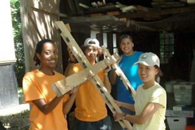 Carrying a frame are MIT freshmen Eden Zeilo from Virginia, left, Josh Raines from New Jersey and Jessica Li of California. Behind them is sophomore Arian Roman, the team leader of a CityDays group volunteering on a project for the Cambridge Historical Society.