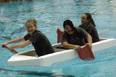 Management senior Rebecca Oman, biology senior Chensi Ouyang and mechanical engineering senior Ellann Cohen together pilot the vessel Ship Happens. The team won the Head of the Zesiger cardboard boat regatta held Oct. 19.