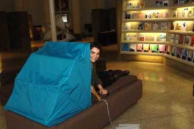Sofia Ponte, an MIT graduate student in architecture, peers around the  canopy of Dreaming Lounge, on display in Barker Library through Feb. 15. Ponte created the furniture prototype for what she hopes will be a refuge for students needing respite from too much analytical thought.