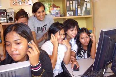 MIT junior Shirin Kasturia works with women in Cambodia
  after giving them donated computers and teaching them basic computing skills.