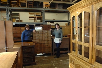 Furniture Exchange volunteer Laura Fuller, left, and manager Judy Halloran, right, stand amidst some of the wonders available at the Exchange for members of the MIT community.