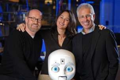 David Kirkpatrick (left), Chairman of Plymouth Rock Studios, Cynthia Breazeal, co-director of Media Lab's Center for Future Storytelling, and Frank Moss, director of the MIT Media Lab, with Nexi, a mobile,  dexterous social robot developed by Breazeal's Personal Robots research group.