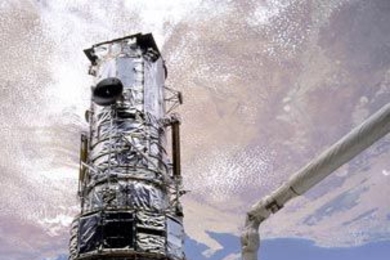 Jeffrey Hoffman, inside the shuttle payload bay, assists F. Story Musgrave, on the robotic arm, during the Hubble telescope's first servicing mission in 1993.