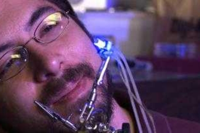 Ed Boyden holding his most recent optogenetic device; an array of optical elements that can turn on and off individual neurons in sixteen different points with the brain.