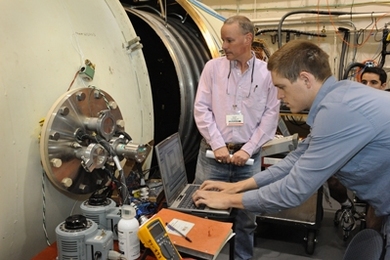 Professor David Miller from the Aeronautics and Astronautics Department works with graduate student and Air Force Lieutenant John Richmond as he verifies thermal sensor performance before starting the next phase of thermal vacuum testing.