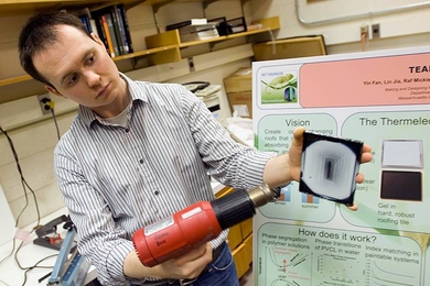 Nick Orf PhD ’09 demonstrates a prototype Thermeleon roof tile, using a heat gun to warm part of it. The heated area turns from black to white.