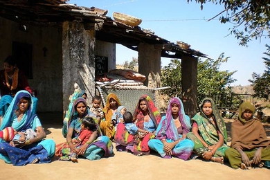 Indian women and children wait at a clinic where J-PAL researchers investigate a better way to bring medical treatment to developing areas.