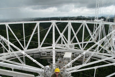 Joe Davis ascends a walkway from the transmission dome suspended 500 feet above the Arecibo radiotelescope dish in Puerto Rico, after his transmission of a message to alien beings.