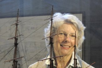 Melville scholar Wyn Kelley, with a model of the 19th century American whaleship, the Charles W. Morgan, one of 40 full-hull models in MIT’s Hart Nautical Gallery.