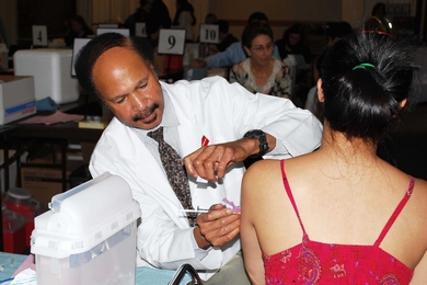 MIT Medical physician assistant George Taylor administers an H1N1 flu shot to a student at the Nov. 17 clinic at MacGregor House.