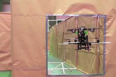 A small, autonomous helicopter, programmed by MIT students under the direction of Professor Nick Roy, passes through a simulated window as part of a competition held over the summer.