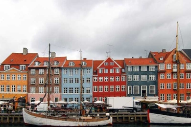 Six brightly colored townhouses in a row built with wood, bricks, and plaster