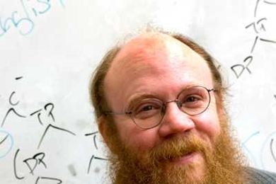 MIT linguistics professor Norvin Richards stands in front of a tree-like sentence diagram often used by linguists.