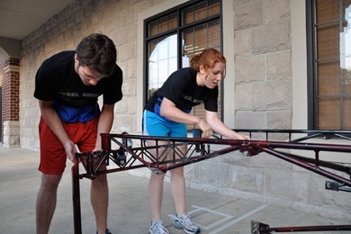Freshman Scott Landers and junior Kim Huppert practice assembling the bridge at a hotel in Purdue, Ind., before the national competition.