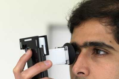 Postdoctoral Associate Ankit Mohan demonstrates NETRA (Near-Eye Tool for Refractive Assessment). The user places the device to the eye and, using phone's keypad, aligns patterns in the viewfinder. These alignments provide the data needed to determine a prescription.
