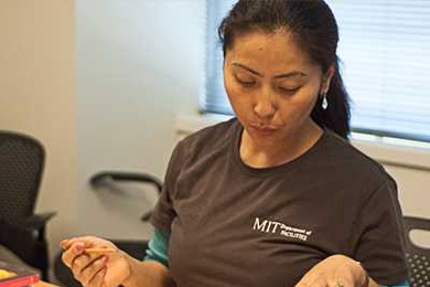 Tsering Mulug-Labrang, a Department of Facilities custodian who was born in India, reviews an assignment during a recent English as a Second Language (ESL) class.