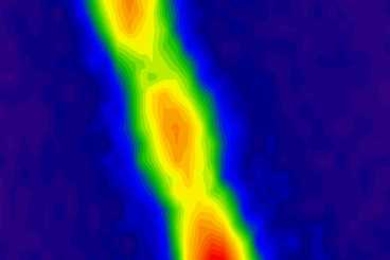 This filament containing about 30 million carbon nanotubes absorbs energy from the sun as photons and then re-emits photons of lower energy, creating the fluorescence seen here. The red regions indicate highest energy intensity, and green and blue are lower intensity.
