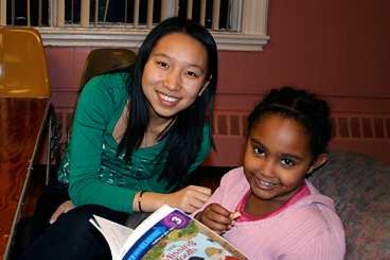 MIT senior Yue Li assists a child at the Cambridge Community Center in increasing her literacy skills via the ReachOut: Help Teach a Child to Read program.