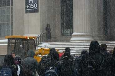 Students trek through a snowy MIT campus.