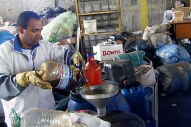 A member of the Rede CataSampa waste-pickers cooperative demonstrates the filtration system for waste vegetable oil that was set up with the help of MIT students.