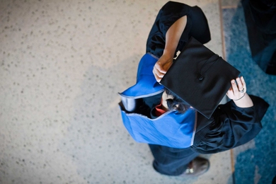 The Next Century Convocation on April 10 included a procession of administrators, faculty, staff, students and alumni. Here, one member of the procession dons the academic regalia.