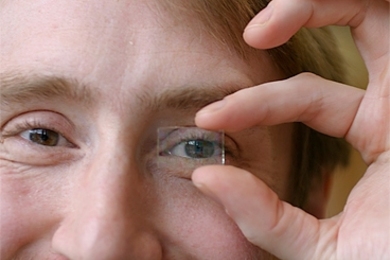 Richard Lunt, one of the researchers who developed the new transparent solar cell, demonstrates its transparency using a prototype cell.