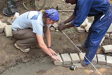 EWB's Tess Saxton-Fox, a junior in mechanical engineering, helps lay the foundation for the village's new rainwater harvesting tank.