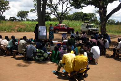 Amy Smith, in blue dress, leads a workshop in a village in Uganda.