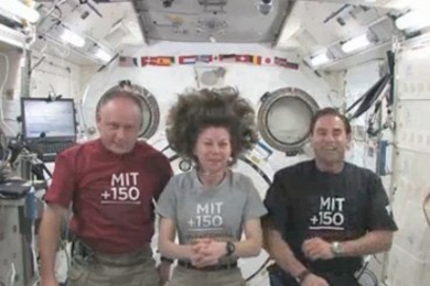 Greg Chamitoff, Cady Coleman, and Mike Fincke pose together on the International Space Station. They each wear an "MIT 150" t-shirt