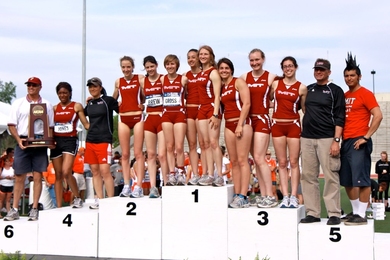 The MIT women’s track and field team stands atop the podium at the NCAA Division III Outdoor Track and Field Championship.