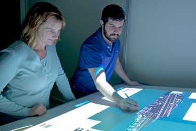 Missy Cummings and student Jason Ryan work on a virtual planning tool designed to organize planes and personnel on aircraft carrier deck.