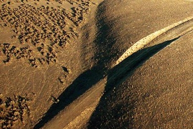 A view looking southeast along the surface trace of the San Andreas fault in the Carrizo Plain. In this image, a road has been cut going through the fault (from left to right).