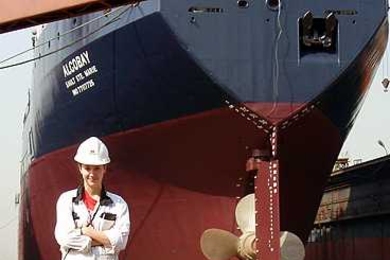 Alicia Lenis, LGO ’13, stands in front of one of the ships she worked on at the Chengxi Shipyard, Jiangyin, China in the fall of 2009.