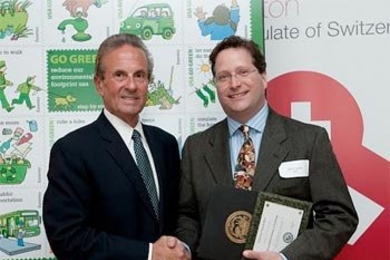 Richard C. Rossi, Cambridge deputy city manager, presents Steven M. Lanou, deputy director for sustainability in the MIT Environment, Health, and Safety Headquarters Office, with a City of Cambridge Go Green Award for MIT's achievements in energy programs.